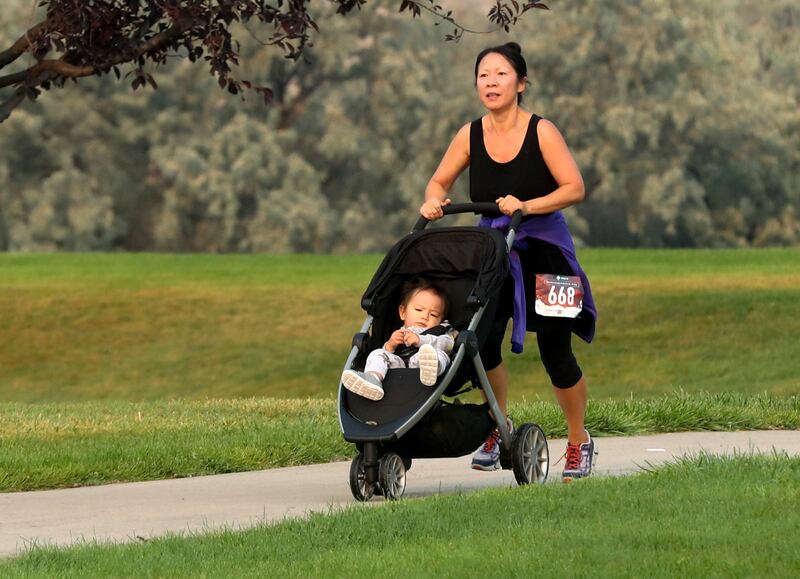 Weihong Wang pushes her son Sammy in a stroller as she nears the finish of the Labor Day Pun Run in Lehi on Sept. 7, 2020.
