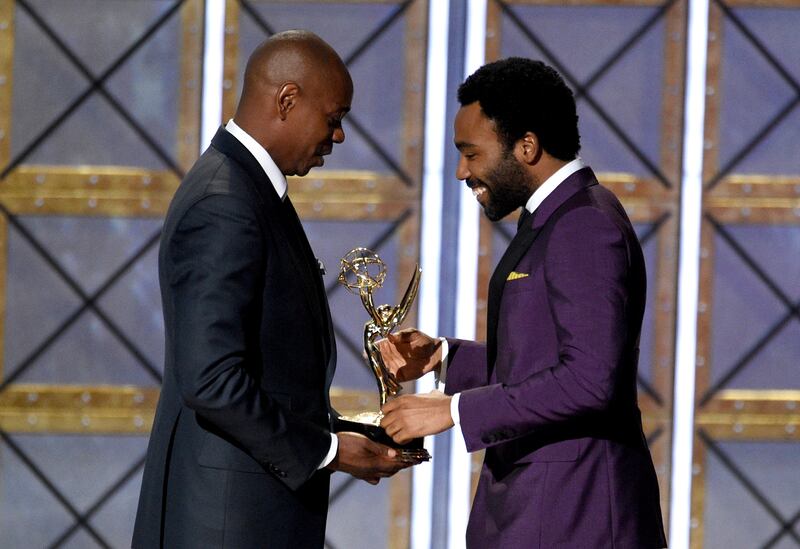 Dave Chappelle, left, presents the award for outstanding directing for a comedy series for the "Atlanta" episode "B.A.N." to Donald Glover at the 69th Primetime Emmy Awards on Sunday, Sept. 17, 2017, at the Microsoft Theater in Los Angeles.