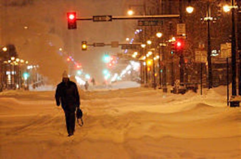 Christopher Pilon walks down the middle of a street in downtown Denver as he makes his way to Union Station to catch a train to Salt Lake City Thursday.