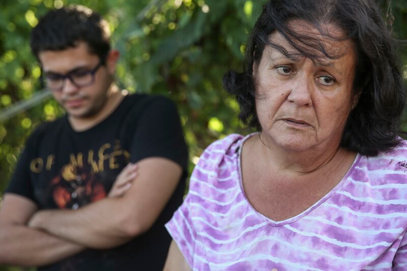 Juanita Arroyo Rivera, right, and her son, Miguel Emmanuel Sanabria Arroyo, left, talk about their effort to purchase new power poles for their community in Juana Díaz, Puerto Rico, on Saturday, Dec. 9, 2017.