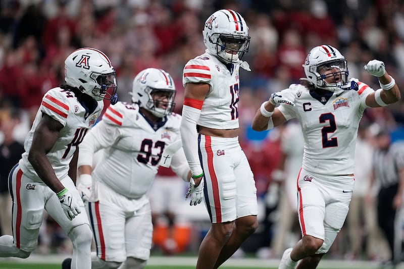 Arizona safety Genesis Smith (12) celebrates with teammates after an interception against Oklahoma .