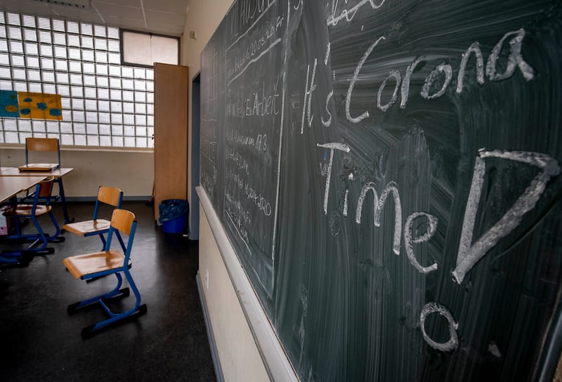 In this Friday, March 13, 2020 file photo the slogan ‘It’s Corona Time’ is written on the chalkboard of an empty classroom of a high school in Frankfurt, Germany.