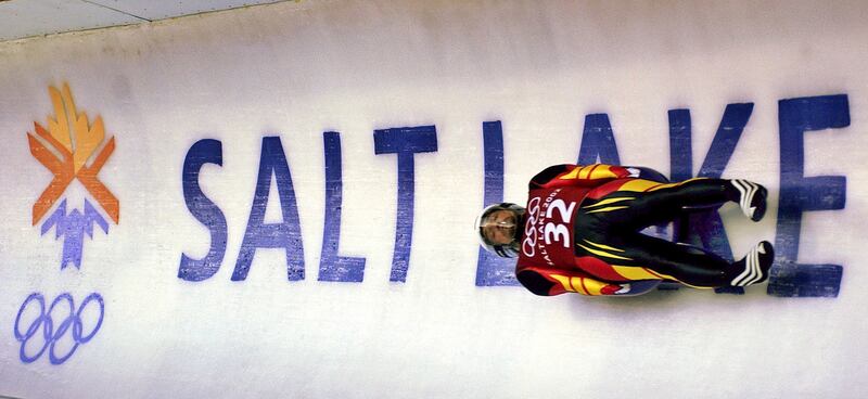FILE - In this Feb. 9, 2002, file photo, Georg Hackl, of Germany, speeds past an Olympic logo during a practice run for the men's singles luge at the 2002 Salt Lake City Winter Olympics in Park City, Utah. Salt Lake City got the green light to bid for an