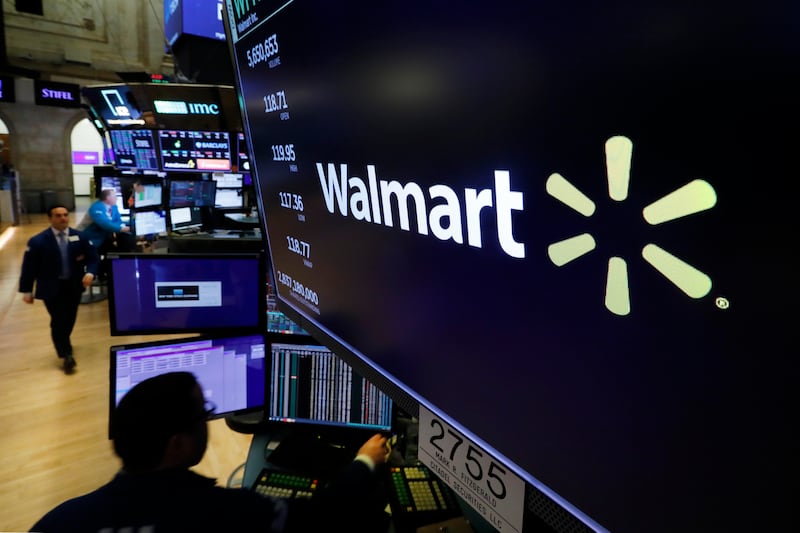 In this Feb. 18, 2020 file photo, the logo for Walmart appears above a trading post on the floor of the New York. Walmart says it has removed ammunition and firearms from displays at some of its stores. The move comes in the wake of the killing of George Floyd that has set off sometimes violent demonstrations against police brutality and injustice against African Americans.