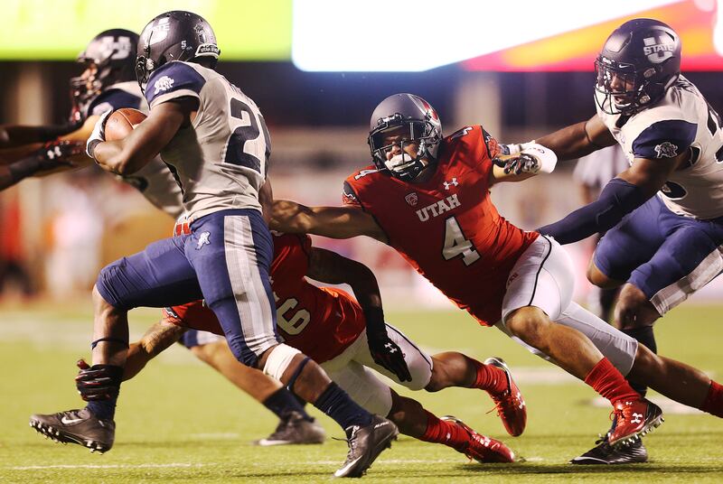 Utah defenders attempt to tackle Utah State’s LaJuan Hunt at Rice-Eccles Stadium in Salt Lake City.