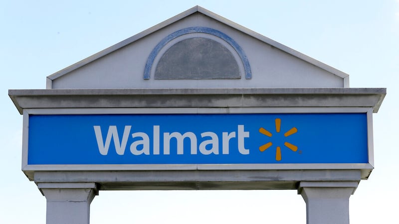 A Walmart logo forms part of a sign outside a Walmart store.