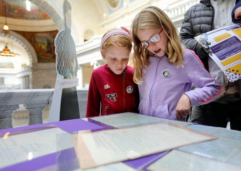 Amelia Wilkes and Lillian Wilkes, great-great-great-great granddaughters of Dr. Martha Hughes Cannon, the nation’s first female state senator, look over documents from when Cannon was in the senate from 1896-1900, during a press conference to celebrate the 125th anniversary of the first Utah woman elected to public office at the Capitol in Salt Lake City on Wednesday, Nov. 3, 2021.