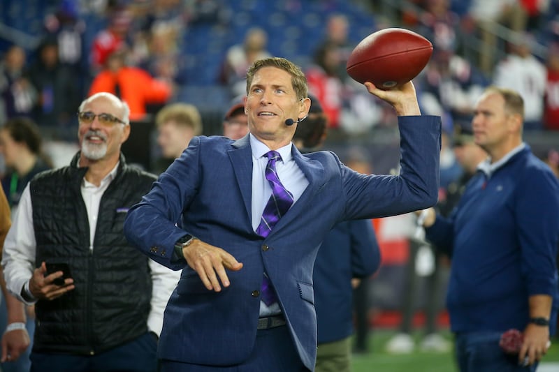 Former NFL quarterback and football analyst Steve Young throws a ball to a fan prior to an NFL football game between the Chicago Bears and New England Patriots, Monday, Oct. 24, 2022, in Foxborough, Mass.