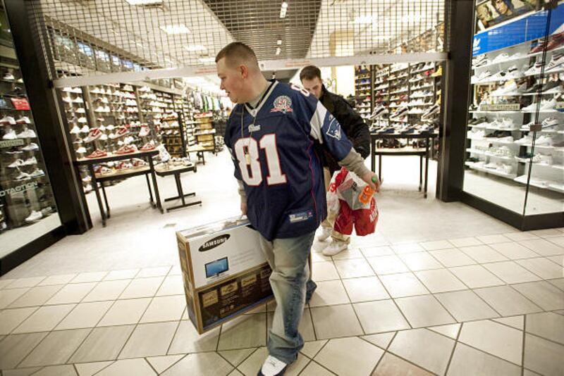 Sean Desio, front, and Nick Putman, both of Whitman, Mass., do some shopping in December. Sales figures fell in the last month of 2009.