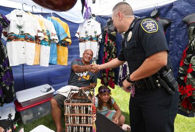 Springville Police Chief Craig Martinez talks with Francis Vaaulu and his daughter, Roses, in their shirt shop as he walks through Art City Days in Springville on Wednesday, June 5, 2019.