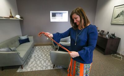 Newly elected Salt Lake County Mayor Jenny Wilson smiles as she holds her a tie from her predecessor, Ben McAdams, in her office in the Salt Lake County Government Center on Thursday, March 28, 2019. McAdams helped Wilson paint the office and got paint on