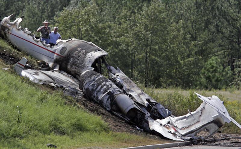 Investigators look over the debris left by the Learjet near the Columbia Metropolitan Airport in Columbia, S.C., on Saturday. Four people were killed in the crash.