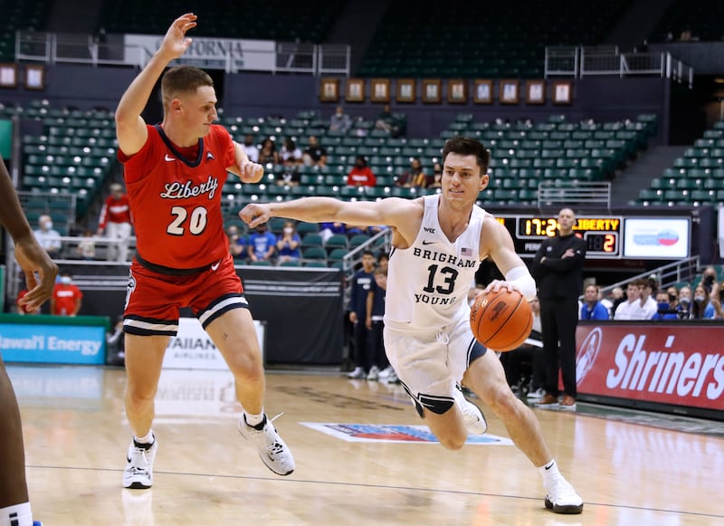 Liberty guard Keegan McDowell, wearing red, defends against BYU guard Alex Barcello, wearing white