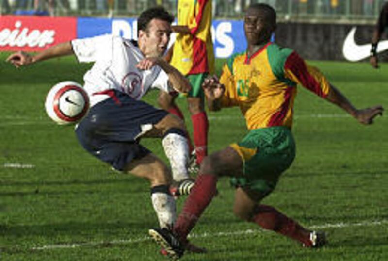 Kerry Zavagnin, left, of the United States and Grenada's Franklyn Baptiste battle for control of the ball during Sunday's qualifying match.