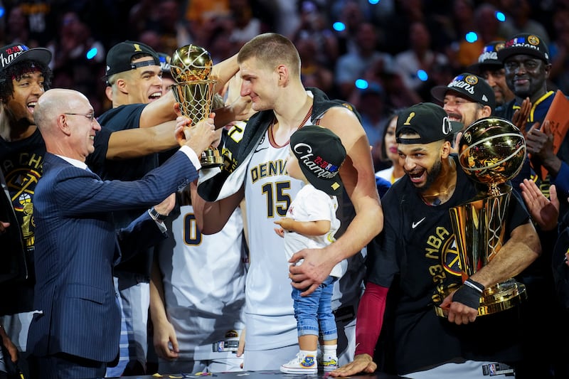 Commissioner Adam Silver hands the Finals MVP award to Denver Nuggets center Nikola Jokic,