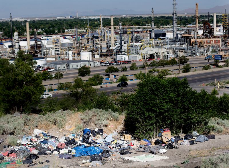 A man sorts through his belongings during a cleanup of homeless camps located east of Victory Road in the foothills north of Salt Lake City on Thursday, June 14, 2018.