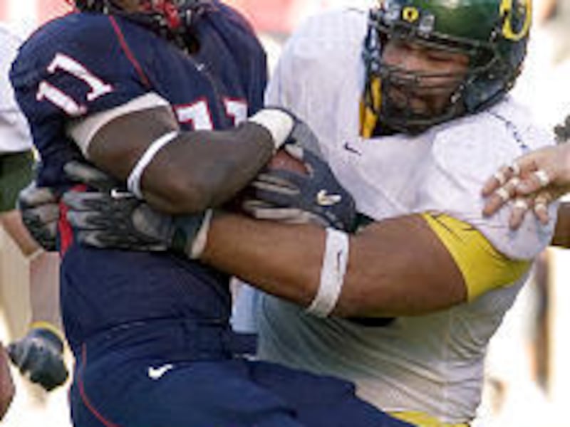 Highland High alumnus Haloti Ngata, right, tackles Arizona's Mike Bell during Ngata's collegiate career at Oregon.