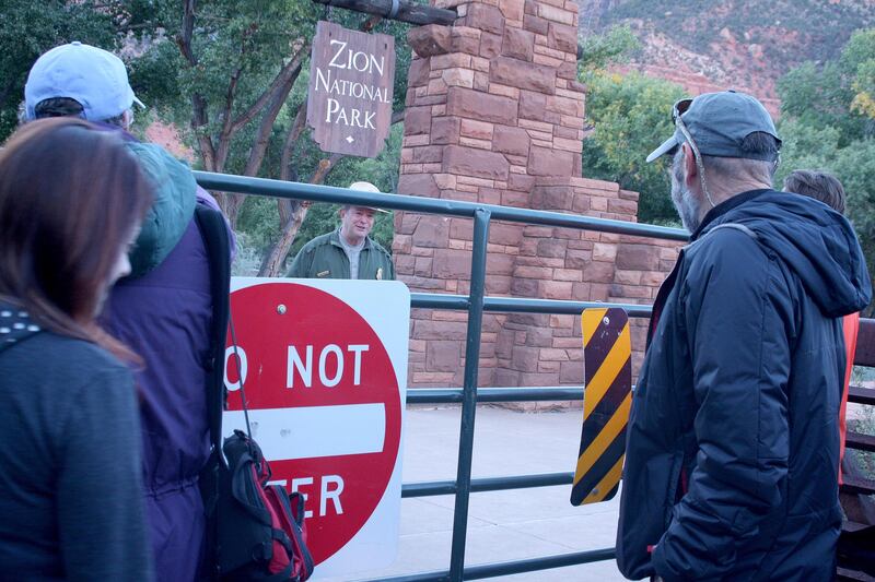 Park rangers talk to protesters before they enter Zion National Park as an act of “civil disobedience.”