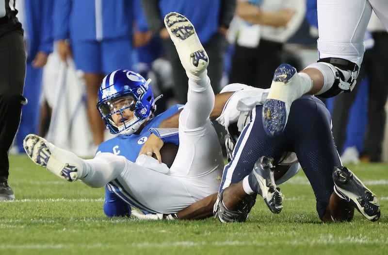 Brigham Young Cougars quarterback Jaren Hall (3) is sacked by Utah State Aggies safety Ike Larsen (19) in Provo on Thursday, Sept. 29, 2022.