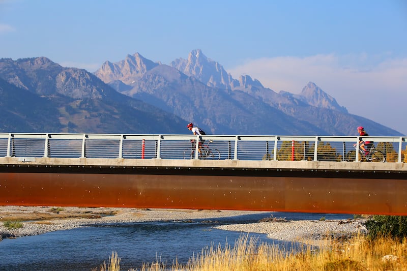 Racers cross the Wilson Bike Path Bridge with the Grand Teton in view during last year’s LoToJa Classic. The finish line at Jackson Hole Mountain Resort is only seven miles away. This year’s 43rd annual LoToJa will be held on Sept. 6.