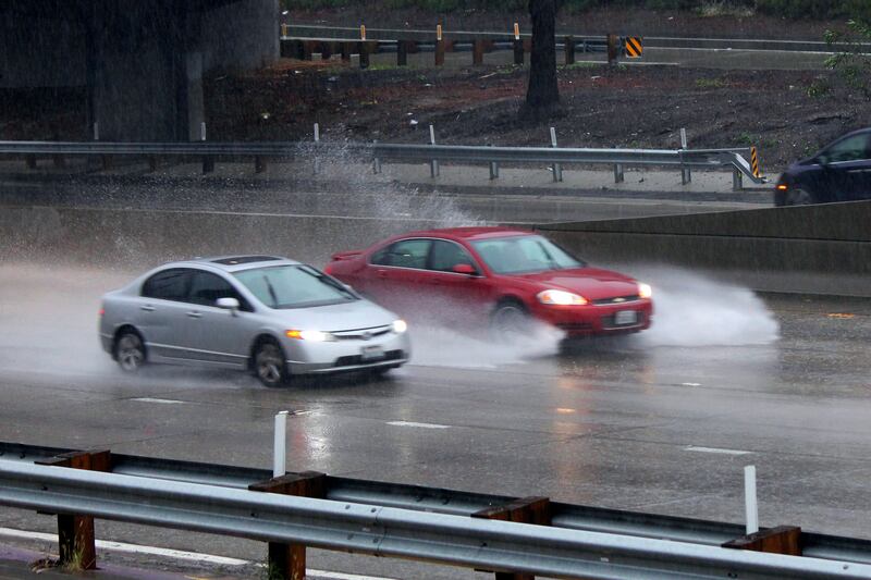 Cars on the northbound Harbor Freeway (I-110) in downtown Los Angeles plow through deep water during a torrential downpour Monday, April 6, 2020.