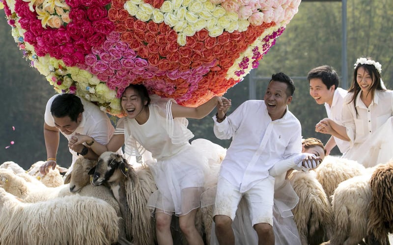 Three newlywed couples from left, Artit Thanajindawong and Daradai Wachirapootthacoon, Prontathorn Pronnapatthun and Chaiyut Phuamgphoeksuk, and Pirat Rungthongoran and Nichapatr Koomsombut frolic at a resort in Ratchaburi province in western Thailand, Fr