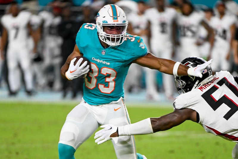 Miami Dolphins running back Chris Brooks (33) runs with the ball as Atlanta Falcons linebacker DeAngelo Malone (51) defends.