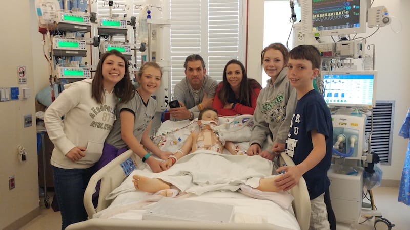 The Bingham family gathers around Gage, the youngest Bingham child, in his hospital room on April 5, 2017, the day of his heart transplant.
