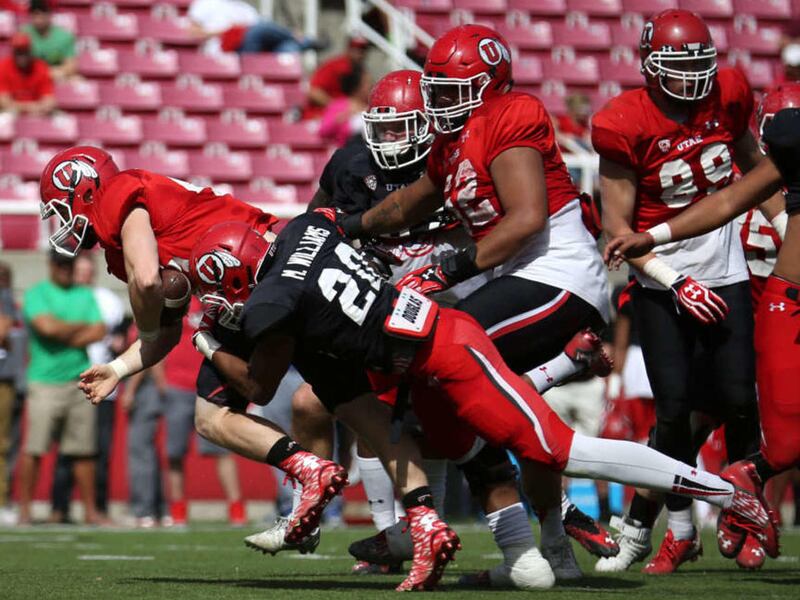 Andrew Fletcher gets tackled by Marcus Williams during a University of Utah football scrimmage at the Rice-Eccles Stadium in Salt Lake City on Saturday, April 11, 2015.