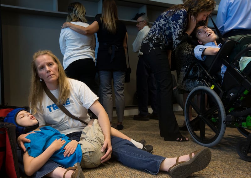 Heather Nelson comforts her son, Matthew, 10, after he collapsed from having a seizure during a press conference at the Utah State Office Building in Salt Lake City on Thursday, Aug. 23, 2018, where a broad coalition of Utah community leaders announced it