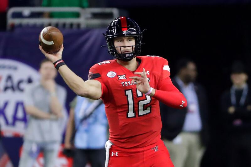 Texas Tech quarterback Tyler Shough (wearing red) passes the ball