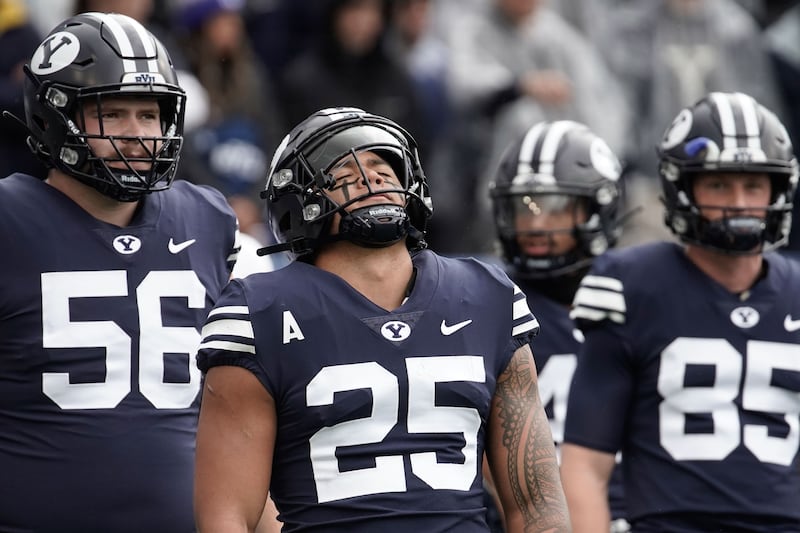 Brigham Young running back Tyler Allgeier closes his eyes as he warms up ahead of an NCAA college football game.