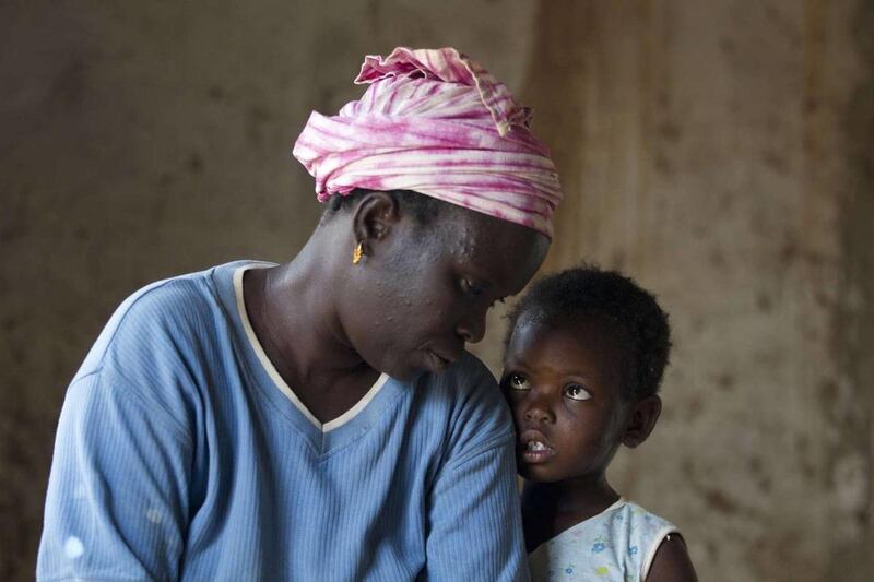 In this Monday, April 30, 2012 photo, Mariam Orgho, 3, looks at her mother, Coumba Seck, The family struggles to find enough food to eat as there is a drought in their region.