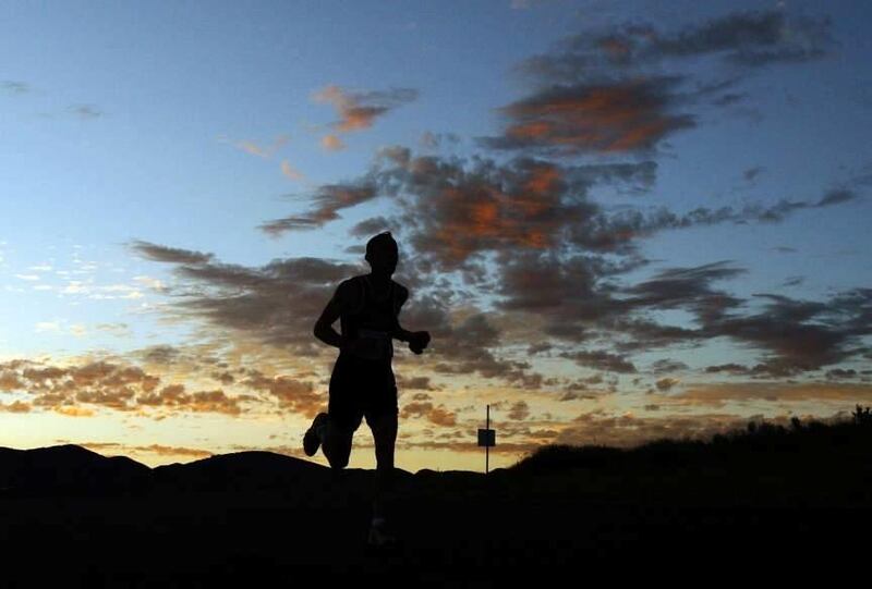 A runner makes his way over a crest in the road at sunrise during the Deseret News Marathon on Monday, July 25.