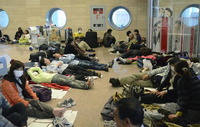 Japanese tourists take rest in the lobby of the Cairo airport as their homebound flights were canceled Sunday, Jan. 30, 2011. Days of protests descended into chaos in the country, with looters roaming the streets and travelers stranded in the airport.