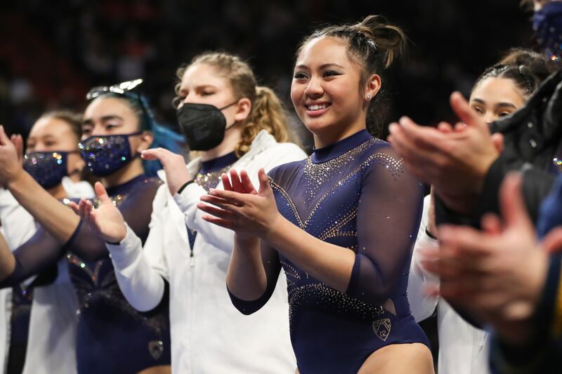 UCLA’s Emma Malabuyo and teammates cheer on Oregon State’s Jade Carey as she competes on the floor during an NCAA gymnastics meet against UC Davis and Oregon State on Sunday, Jan. 23, 2022, in Corvallis, Ore.