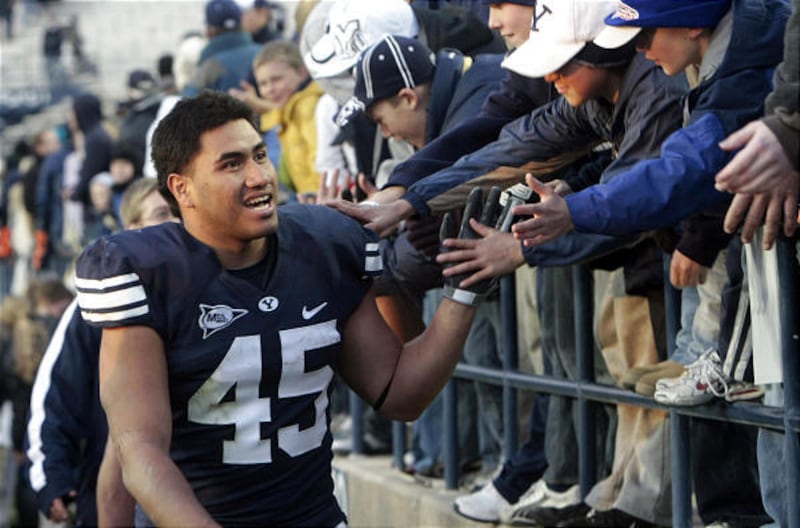 BYU's Harvey Unga (45) shakes hands with fans after BYU defeated Air Force Saturday. Unga became BYU's all-time leading rusher.