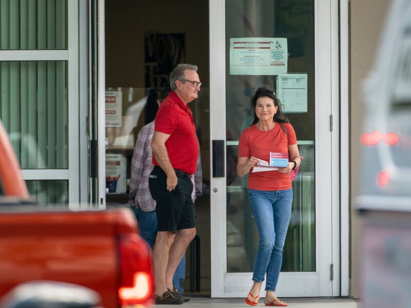 Voters exit the polls after casting their ballots at the Supervisor of Elections Main Office in West Palm Beach, Fla.