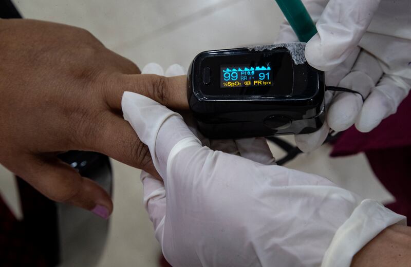 A health worker uses a pulse oximeter to check the oxygen saturation level of another after administering COVID-19 vaccine at a hospital in Gauhati, India, Thursday, Jan. 21, 2021. India kicked off its massive vaccination drive on Jan. 17, with a goal of inoculating 300 million of its nearly 1.4 billion people.
