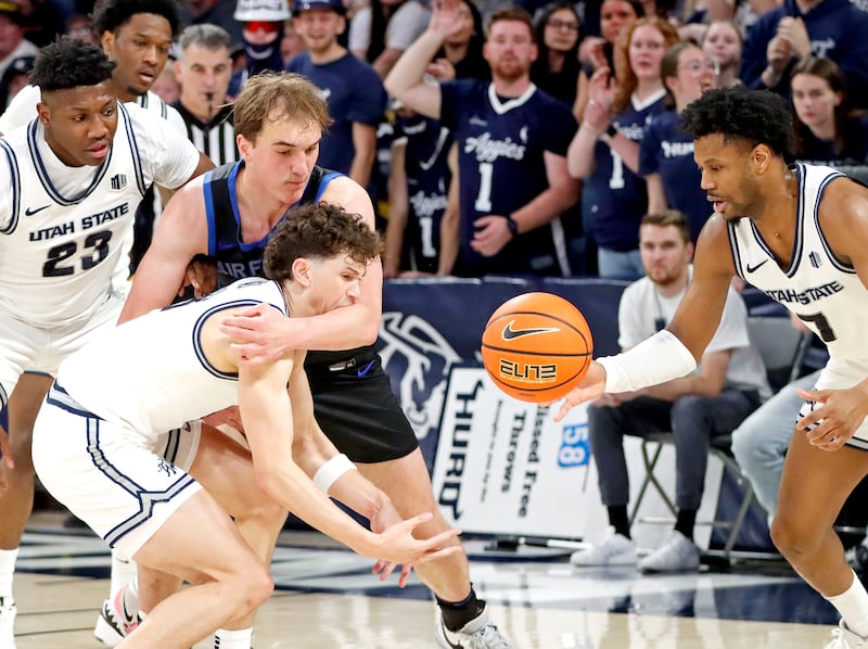 Utah State guard Drake Allen, left, gets a taste of Air Force center Wesley Celichowski's arm as teammate Dexter Akanno corrals a loose ball during the Aggies' 87-47 win on March 8, at the Spectrum in Logan.