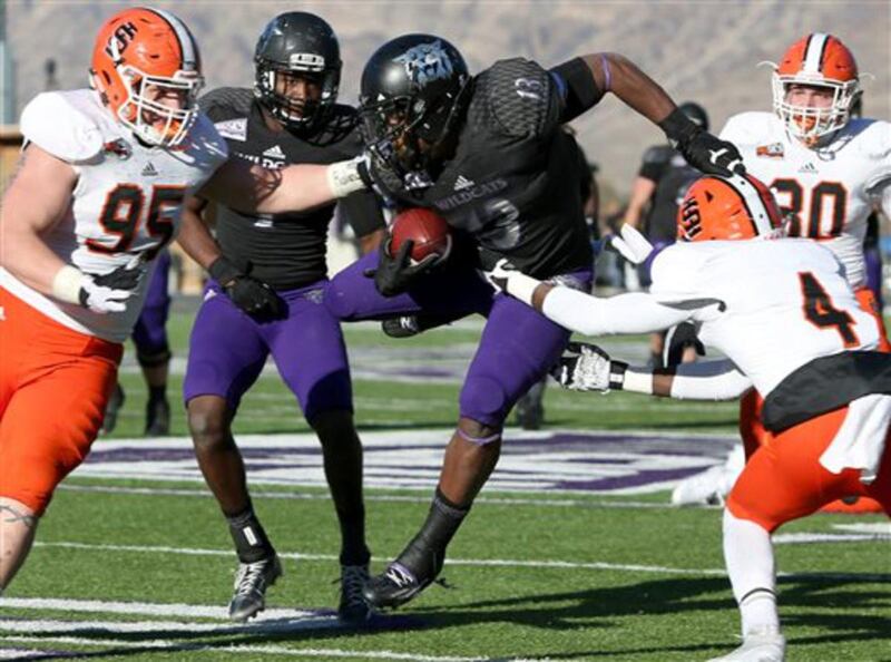 Weber State's Eric Wilkes cuts through a group of Idaho State defenders during an NCAA college football game Saturday, Nov. 21, 2015, in Ogden, Utah. Weber State defeated Idaho State 35-14. (Benjamin Zack/Standard-Examiner via AP)