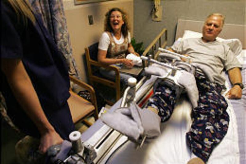 Randy Thornton, right, laughs with his wife, Gwen, and a nurse during his recovery.