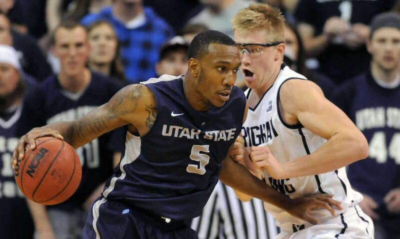 Utah State Aggies center Jarred Shaw (5) drives to the basket as Brigham Young Cougars forward Eric Mika (00) defends during a game at EnergySolutions Arena on Saturday, November 30, 2013.