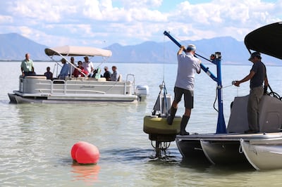 Workers replace a water quality monitor called a sonde as state legislators tour Utah Lake on Wednesday, Sept. 13, 2017.