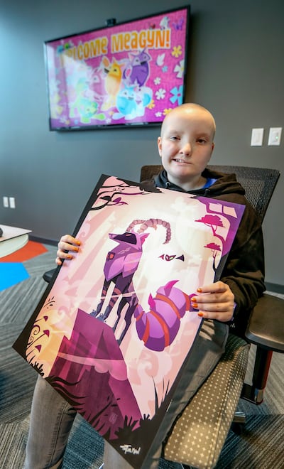 Meagyn Moeller, 12, holds a printed poster of the wolf avatar she created for the online game “Animal Jam” at WildWorks' offices in Draper on Thursday, Oct. 25, 2018. The Make-A-Wish Foundation flew Meagyn, who was diagnosed with a brain tumor in June 201