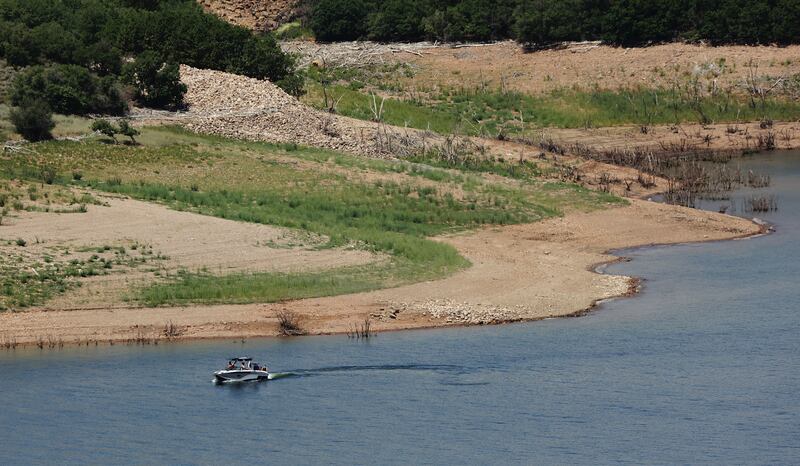 A boater floats at Jordanelle Stake park, where drought has reduced water levels.