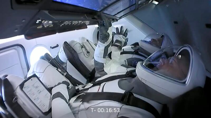 In this Wednesday, May 27, 2020 image from video made available by SpaceX, NASA astronauts Bob Behnken, background left, and Doug Hurley sit in the Crew Dragon capsule as the launch from the Kennedy Space Center in Cape Canaveral, Fla., is aborted due to weather problems. (SpaceX via AP)