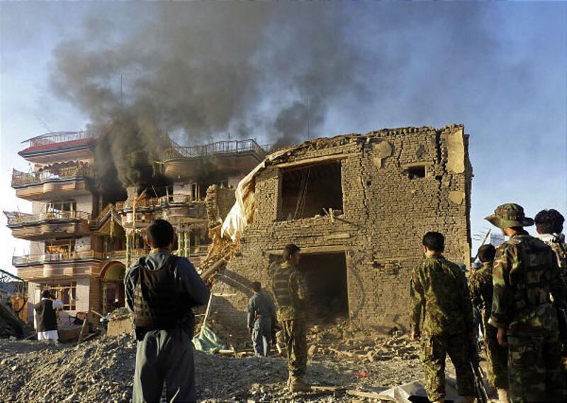 Afghan security forces stand outside a USAID compound in Kunduz, Afghanistan, after the attack Friday.