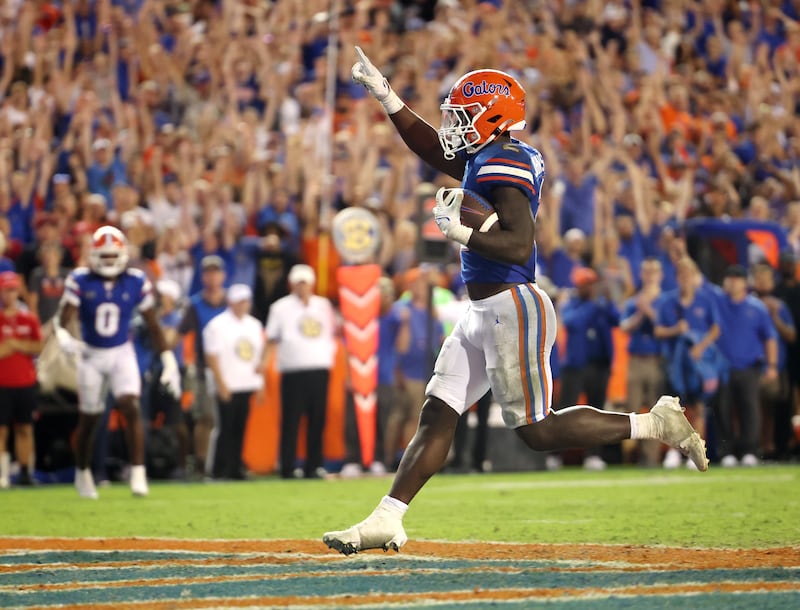 Florida Gators running back Montrell Johnson Jr., wearing blue, scores a touchdown