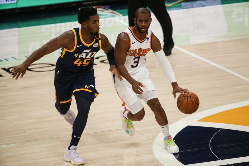 Phoenix Suns guard Chris Paul dribbles against Utah Jazz guard Donovan Mitchell in Salt Lake City, Utah.